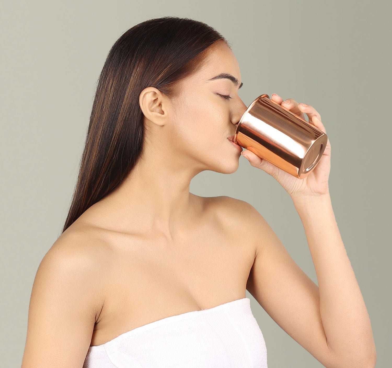Woman drinking water from Ayurvedic copper glass cup by Art of Vedas - traditional copper vessel for health and wellness