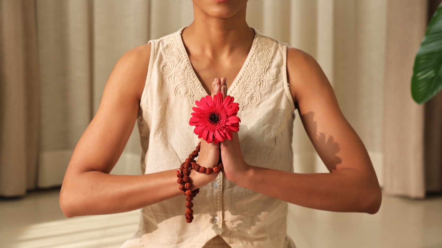 Kvinde med en blomst i en Namaskar-gestus for Art of Vedas